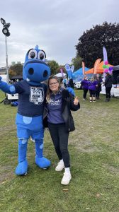 Woman standing with blue mascot 