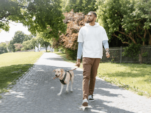 A man walking outside with his pet dog