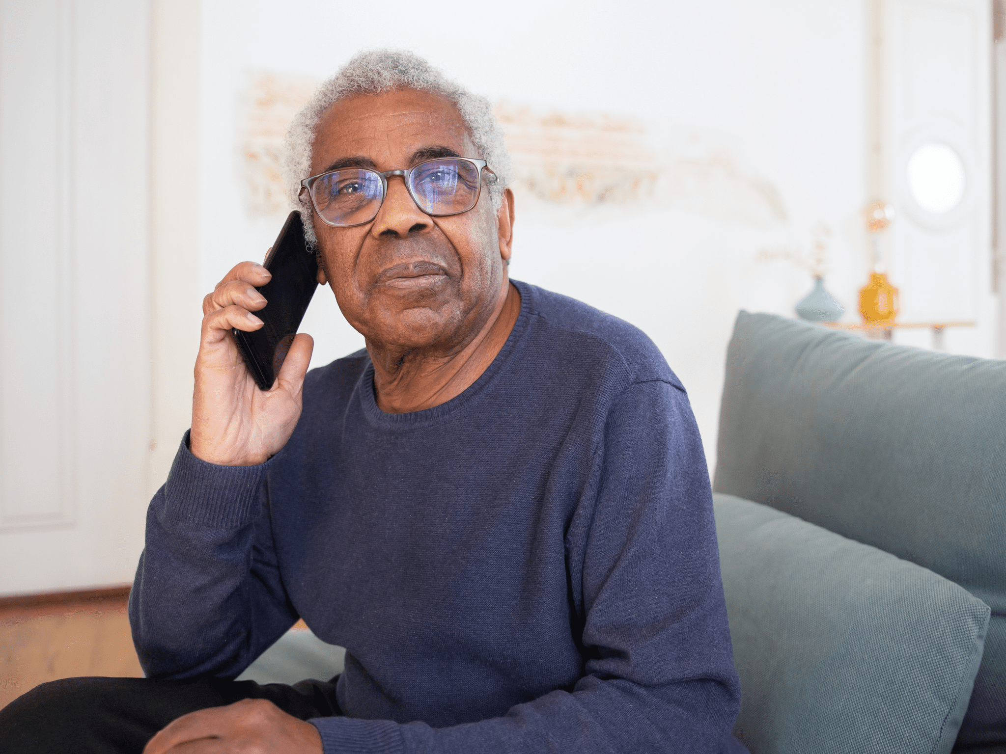 Man speaking on the telephone sitting on sofa