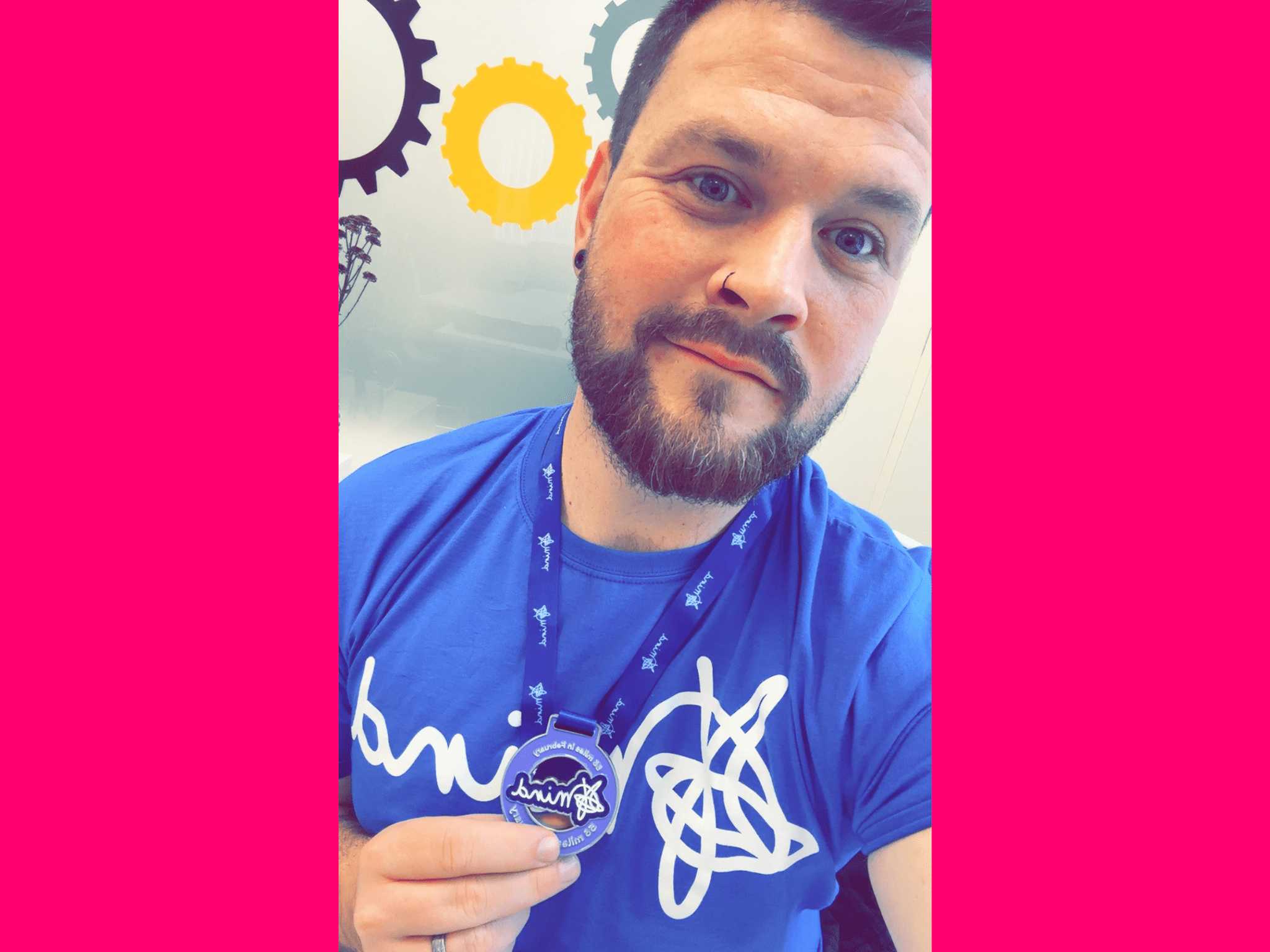 man in blue t-shirt holding medal